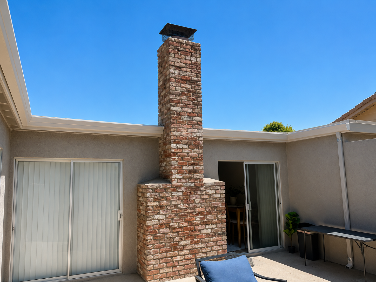 Seamless aluminum gutters wrapping a courtyard around a brick chimney
